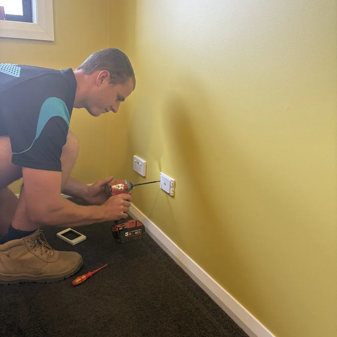 RB Solar & Electrical technician installing a wall point beside a powerpoint